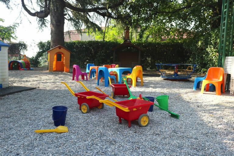 Giochi e piccoli tavoli nel giardino alberato della Scuola Santo Stefano a Brescia